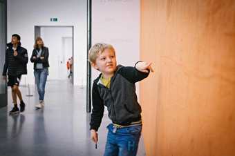 boy drawing on wall with fingers