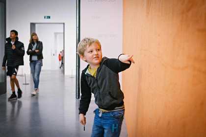 boy drawing on wall with fingers