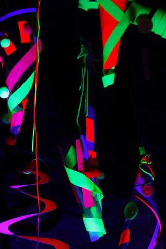Dark image with bright neon lights of people in the Drawing Disco