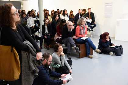 people in gallery listening to a talk