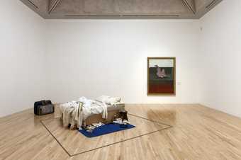 installation photograph of Tracey Emin's My Bed next to a Francis Bacon painting