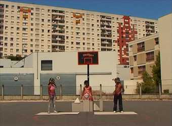 Colour photograph of three people standing outside a building