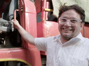 Ernesto Salmerón next to a large red truck