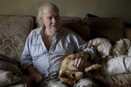 A man sits on the sofa with his dog