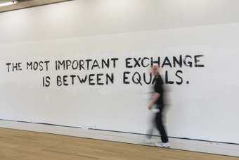 A man walks past a display with the words 'The most important exchange is between equals'