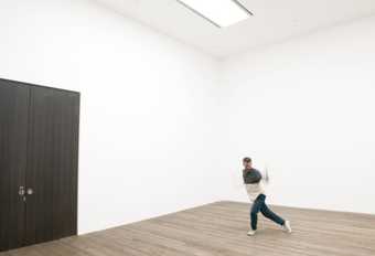 blurred dancer dancing across a gallery room by a set of exit doors