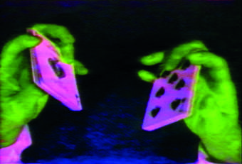 Picture of two green hands holding two pink playing cards