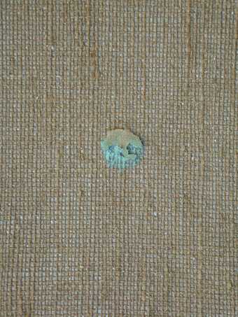 Detail of reverse of canvas where turquoise paint has seeped through hole