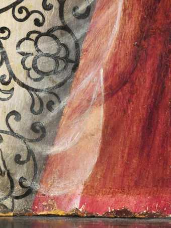 Fig.12 Detail of the red costume at the lower edge, where it would have been protected by the rebate of the frame. The original red glaze is the brighter strip immediately above the edge.
