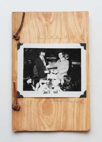 Fig.14 Photograph of the front cover of Business Cards, and artists book by Ed Ruscha and Billy Al Bengston; bound in faux woodgrain paper with a black-and-white photograph of two men in suits shaking hands and looking at the camera