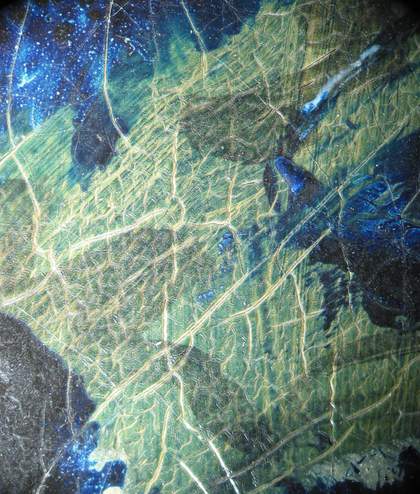 Micrograph showing the first paint layers of the skull, glimpsed between later additions