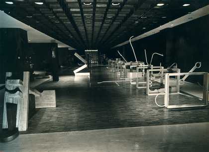Black-and-white photograph of a large exhibition hall, with Roberto Chabet’s Hurdling 1970, a series of vertically suspended frames (a reference to athletic hurdles) from which stem jagged protrusions made of found scraps of metal
