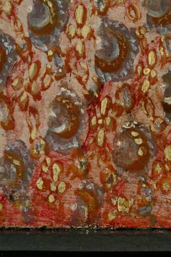 Detail of the dress at the lower edge where it has been protected from light by the frame. Unfaded red glaze and applied patterning on top of it 