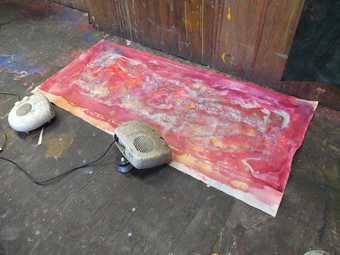 Fig.21 A painting, mid-process, drying on the floor with the assistance of fan heaters