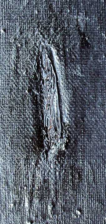 Detail of tear in leg filled with black paint