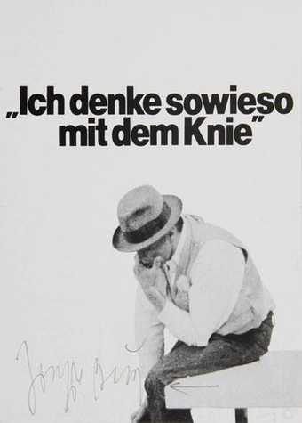 Postcard image of Joseph Beuys, wearing his trademark hat, head in hand, elbow on knee, seemingly in deep thought. Black text above reads "Ich denke sowieso mit dem Knie"