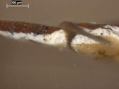 Fig.3 Cross-section through the dark red trousers at the bottom edge, photographed at x250 magnification. From the bottom: chalk ground; greyish beige priming; dark red paint