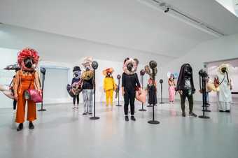 Fig.3 Kevin Beasley Your face is / is not enough 2016, performance at Liverpool Biennial 2018, Tate Liverpool, 14 July 2018 Microphone stands, gas masks, megaphones, polyurethane foam, polyurethane resin, clothing, feathers, baseball caps, umbrella frame
