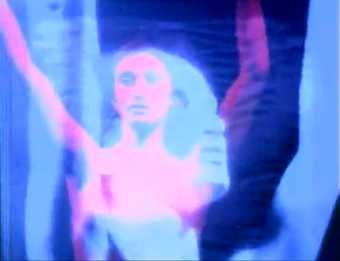 Still image from a video by Nam June Paik featuring layered images of a woman's face with arms in the air in shades of purple, blue and pink