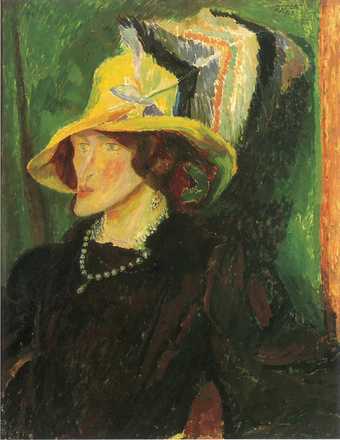 A portrait showing the head and shoulders of a figure who sits facing the left side of the scene, and wears dark clothing, strings of pearls and a yellow hat