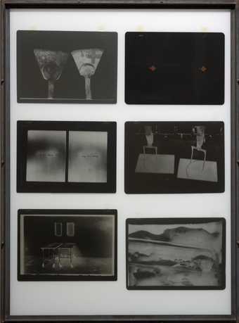 A photographic multiple comprising six large photographic negatives, arranged in two columns of three, suspended between glass plates in an iron frame.