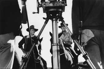 Fig.4 Black-and-white photograph with camera tripod in foreground, showing actors John Wayne and Dean Martin on horseback on a film set