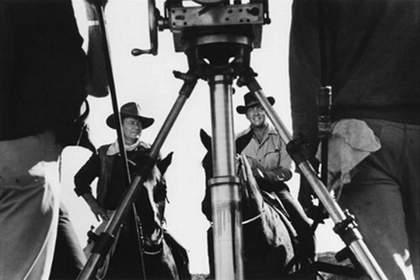 Fig.4 Black-and-white photograph with camera tripod in foreground, showing actors John Wayne and Dean Martin on horseback on a film set