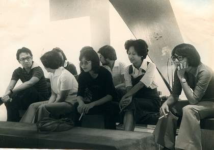 Black-and-white photograph of the audience at Sound Bags and Three Kings, most of them young and fashionably dressed (e.g. flared trousers and large glasses or sunglasses), some smoking cigarettes