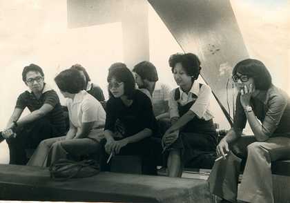 Black-and-white photograph of the audience at Sound Bags and Three Kings, most of them young and fashionably dressed (e.g. flared trousers and large glasses or sunglasses), some smoking cigarettes