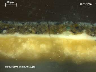Fig.6 Cross-section through the background at the top edge, photographed at x320 magnification. From the bottom: off-white ground; white priming; brown underpaint of background; grey paint of background; varnish