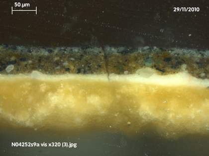 Fig.6 Cross-section through the background at the top edge, photographed at x320 magnification. From the bottom: off-white ground; white priming; brown underpaint of background; grey paint of background; varnish