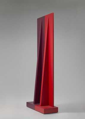 Photograph of a red geometric sculpture; two slender triangles support a larger vertical rectangle, all sitting on a thick rectangular base