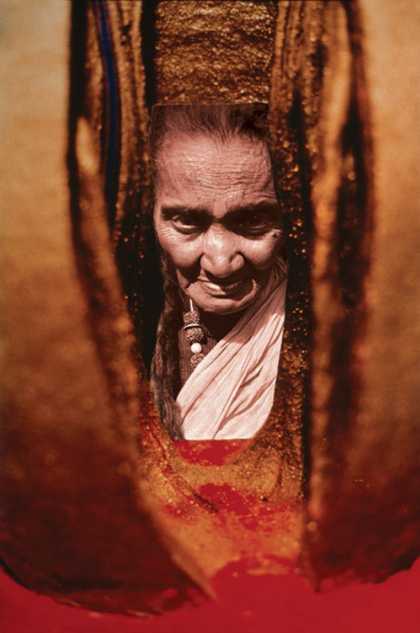 A close-up view of portrait photograph set within a sculpture made of vertical pieces of terracotta that frame it on either side.