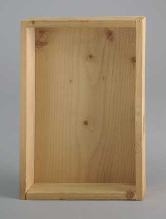 Photograph of a shallow, 5-sided, rectangular wooden box. Inside Beuys has drawn two lines in pencil and written the word 'Intuition' above them