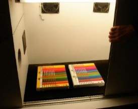 Two of the striped test panels, the left with amber-dyed resin and the right with undyed resin, during accelerated ageing