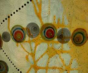 Detail from the right shoulder of the sitter in No Woman, No Cry, showing amber and turquoise coloured polyester resin of various thicknesses, collage discs inspired by the circular patterns produced by a Spirograph, and detailed drawing in graphite penci