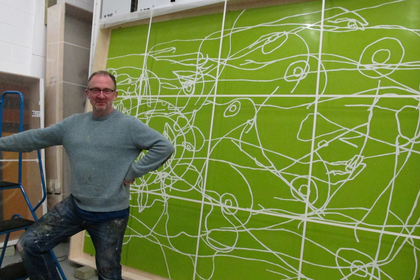 An informal, behind-the-scenes photograph of the artist with Water Painting propped up behind him in a wooden packing frame.