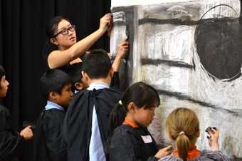 A group of children drawing in a workshop by Zhen Chew