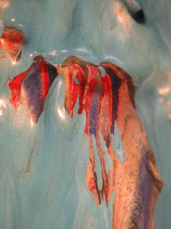 Micrograph showing multi-coloured paint beneath the blue