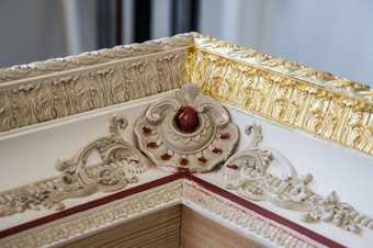 In the photograph the outside section of the frame is gilded on one edge, whereas most of the rest is still white, with areas and lines of dark red bole in preparation for gilding.