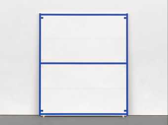 A painting of blue lines and tabs enclosing white spaces, standing on wedges and leaning against a gallery wall.