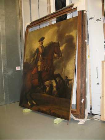 A painting leaning against the wall in the storage room