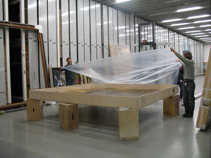 Art handles covering a painting in plastic