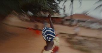 A figure seen from behind against the blurred streets of Bissau