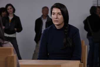 The artist, Marina Abramović, sitting at a desk