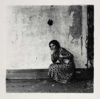 Francesca Woodman crouching by a wall