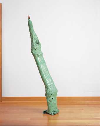 Pale green sculpture by Franz West which is free standing, long and thin with a tapered end