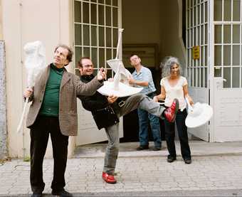 Franz West, Reinhard Bernsteiner, Herbert Flois and Songül Boyraz posing with Passstücke outside the artist's studio in Vienna, 2007, photographed by Lukas Schaller