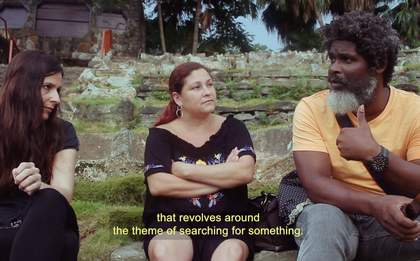 Three adults sitting in a public park in Havana