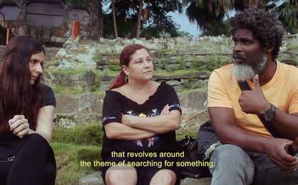 Three adults sitting in a public park in Havana